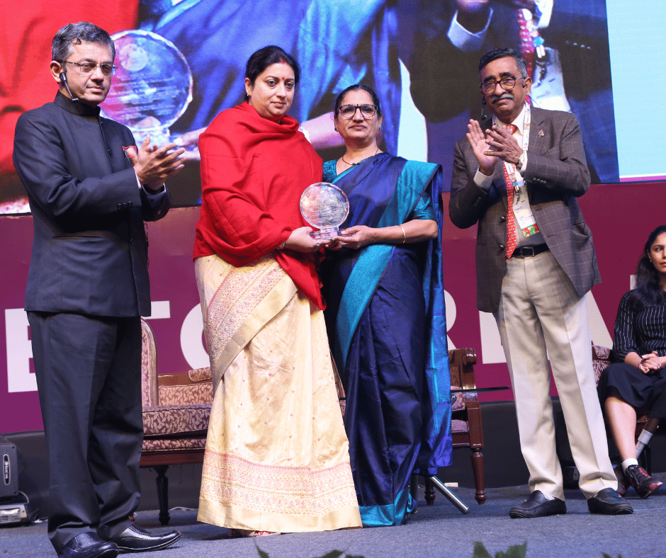 Rescue Foundation president Triveni Acharya receiving an award on stage, applauded by officials.