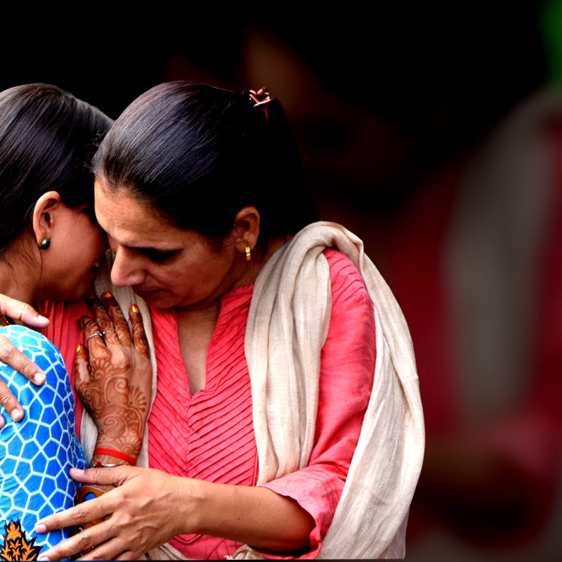 Rescue Foundation president Triveni Acharya holding a rescued girl, who rests her head on her shoulder.